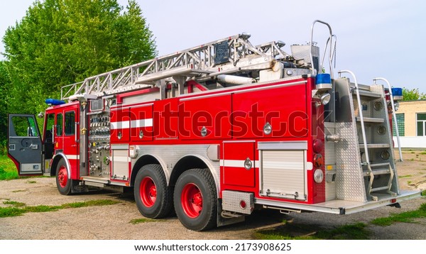 A fire truck with a retractable ladder for the\
delivery of firefighters to the place of fire and the supply of\
extinguishing agents to the burning hearth. Fire truck in the open\
air. Fire safety.