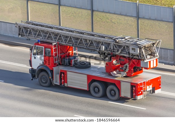 Fire\
truck with retractable ladder drives on the\
highway