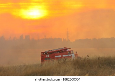 Fire Truck In A Smoky Field On Sunset