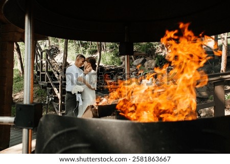 Similar – Image, Stock Photo Laughing couple enjoying fire tongs punch at a Christmas market, holding steaming red mugs with blue flames.