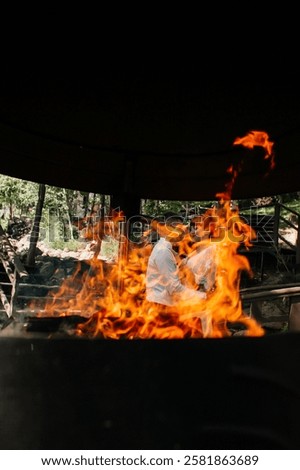 Similar – Image, Stock Photo Laughing couple enjoying fire tongs punch at a Christmas market, holding steaming red mugs with blue flames.