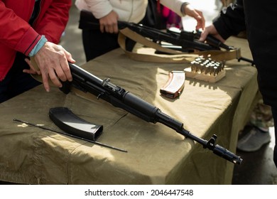 Firearm. Training in the possession of the machine. Lesson on the analysis of a firearm. A person learns to service automatic weapons.