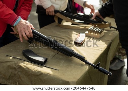Firearm. Training in the possession of the machine. Lesson on the analysis of a firearm. A person learns to service automatic weapons.