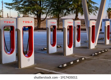 Firebaugh, USA - January 21, 2021: Rows of empty electric Tesla superchargers by California Highway 5