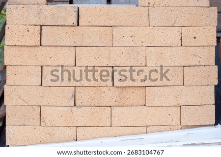 Firebricks in a stack, forming a uniform textured surface, ready for construction work, representing a durable and indispensable building material for fire protection work