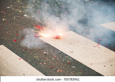 Firecracker exploding on the asphalt of a street