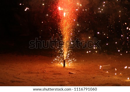 a firecracker with red spark during Hari Raya celebration. eidul Fitri concept. image contain grain and soft focus. 