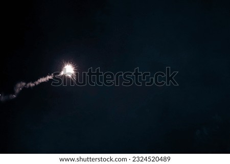 Firecracker with its smoky tail about to burst. From the distance it gives the impression of a missile, comet or meteorite falling on the Earth's surface.
