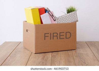 Fired Businessman Box With Pink Slip On Office Desk