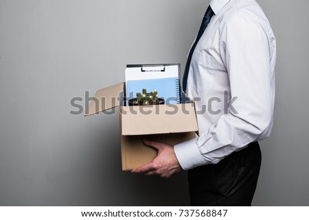 fired businessman packing office supplies in cardboard box at workplace