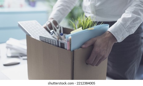 Fired office worker packing his belongings in a cardboard box and leaving the office, crisis and unemployment concept - Powered by Shutterstock