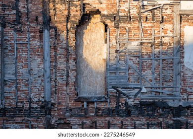 Fire-damanged brickwork with boarded-up door