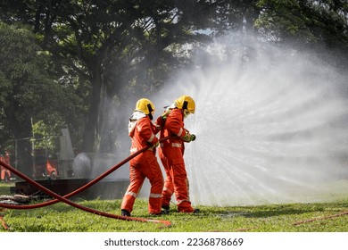 Firefighter Concept. Fireman using water and extinguisher to fighting with fire flame. firefighters fighting a fire with a hose and water during a firefighting training exercise