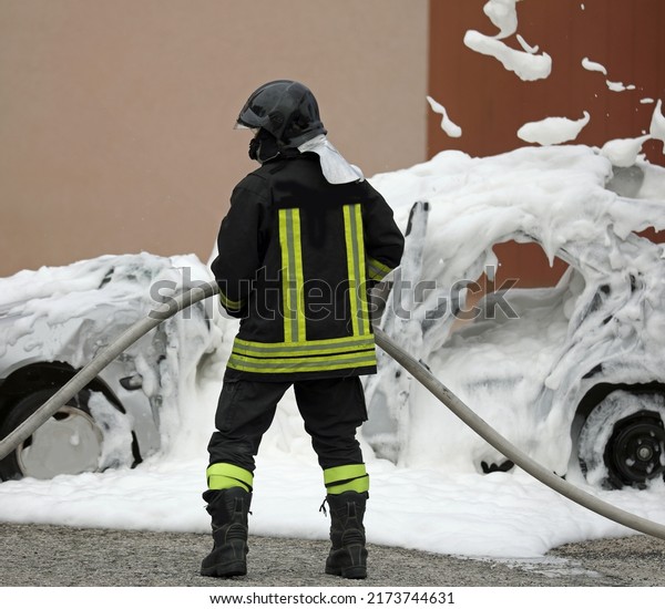 Firefighter and the covered car with white foam\
after the collision