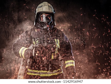 A firefighter dressed in a uniform in a studio.