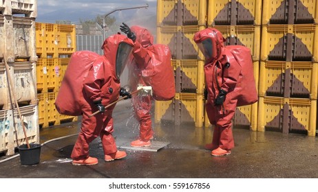 Firefighter Dressing Protective Suit Cleans Up After Sealing A Leaking Container From Corrosive Toxic Hazardous Material Ammonia In Fruit Factory, Yesud Hamaala, Israel, March 21, 2016.