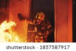 Firefighter entering through the door of the burning house. High quality photo