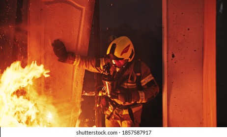 Firefighter Entering Through The Door Of The Burning House. High Quality Photo