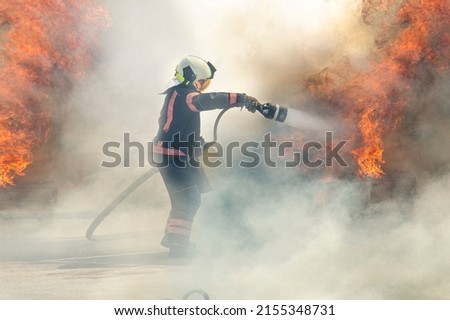 firefighter extinguishes a fire. The hero firefighter stands among the smoke and fire and extinguishes the fire with a stream of water. Foto stock © 