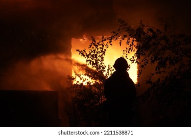 Firefighter In Front Of Burning Building