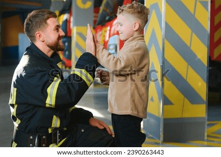 Firefighter holding child boy to save him in fire and smoke,Firemen rescue the boys from fire. Stock foto © 
