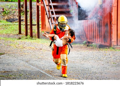 Firefighter Hug The Thai Child Out Of The Fire.Protect People From Dangerous With Brave Heart.Hero In Fireman With Uniform Safe Children From Burn Smoke.