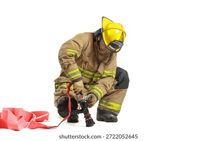 Firefighter kneeling while handling fire hose nozzle, wearing full protective gear and helmet, isolated on white background. Emergency response, fire safety training, rescue, and protective equipment.