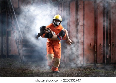 Firefighter man help Asian little girl from out container with smoke from fire.Firefighter rescue team training help people from fire accident simulation. - Shutterstock ID 2200331747