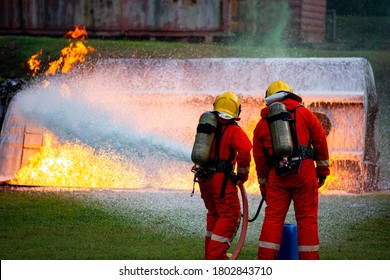 Firefighter On Working By Using Using Extinguisher Water For Put Out The Fire With Foam Chemical. Oil Petroleum Truck Car Upside Down Explosion Crash.