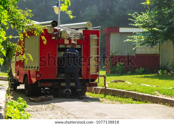 Firefighter is preparing the gear for firefighting,\
rescue, red firefighting\
car