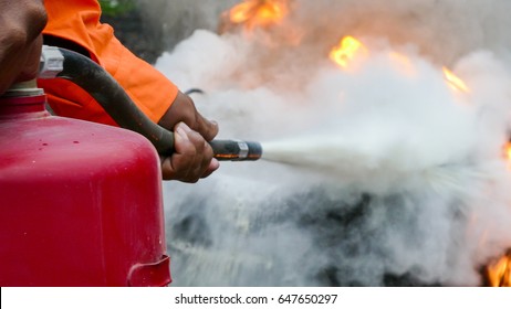 Firefighter Putting Out A Fire With A Powder Type Extinguisher.
