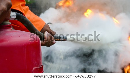 Firefighter putting out a fire with a powder type extinguisher.
 Stockfoto © 