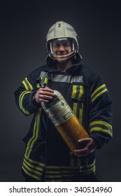 Firefighter Rescue Holds Yellow Oxygen Tank. Isolated On Grey Background.