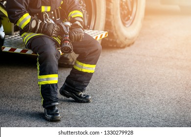 Firefighter Rescue man. Firefighter in uniform and  helmet near fire engine.