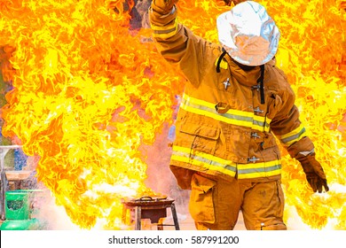 Firefighter training., fireman using water and extinguisher to fighting with fire flame in an emergency situation., under danger situation firemen wearing fire fighter suit for safety