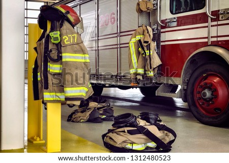 Firefighter truck and protection gear in firehouse