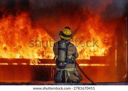 Firefighter try to control and extinguish the blaze fire flame