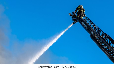 Firefighter trying to put out a fire at a residential building. A risky job only the brave. Essential workers at their duty.