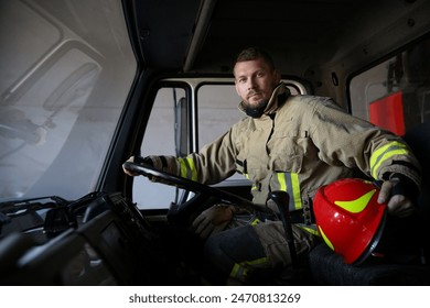 Firefighter in uniform with helmet driving modern fire truck - Powered by Shutterstock