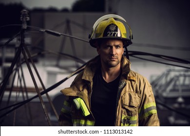 Firefighter with uniform and helmet stand in front of electric wire on a roof top