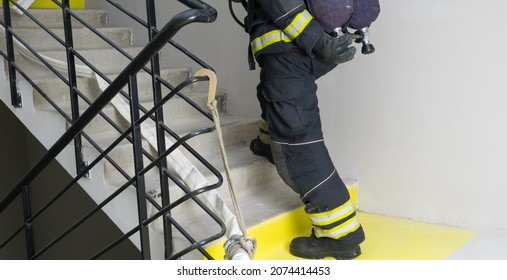 The Firefighter Unscrews The Valve Of The Air Apparatus Of One Of The Cylinders, Going Up The Stairs