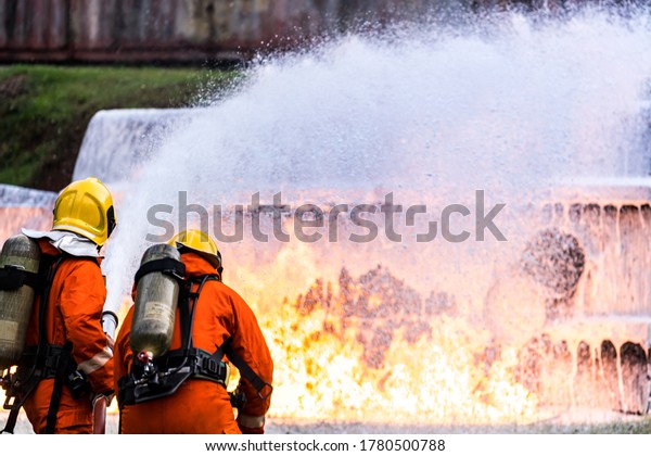 Firefighter using\
Chemical foam fire extinguisher to fighting with the fire flame\
from oil tanker truck accident. Firefighter safety disaster\
accident and public service\
concept.
