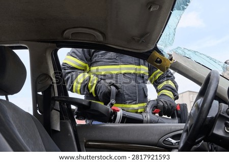 Firefighter Using Hydraulic Rescue Tool For Vehicle Extrication During Car Accident Rescue Scene
