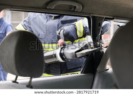 Firefighter Using Hydraulic Rescue Tool For Vehicle Extrication During Emergency Car Accident Response