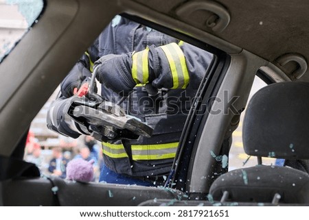Firefighter Using Hydraulic Spreader (Jaws of Life) During Vehicle Extrication Through Car Window