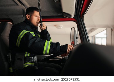 Firefighter using radio set while driving fire truck