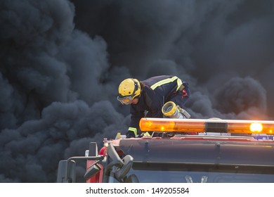 Firefighter Working Over A Truck During A Fire