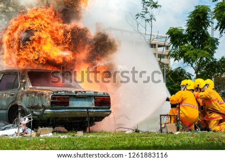 Firefighter,firefighter training, fireman using water and extinguisher to fighting with fire flame in accident car on road.