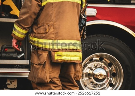 Firefighters in action, using hoses to put out a large fire. Dressed in protective gear, they work together in a smoky, dangerous environment.