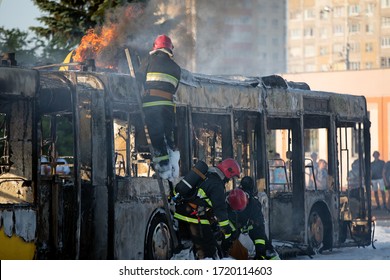 Firefighters crew team extinguish burning coach with foam. Public transit bus had caught fire